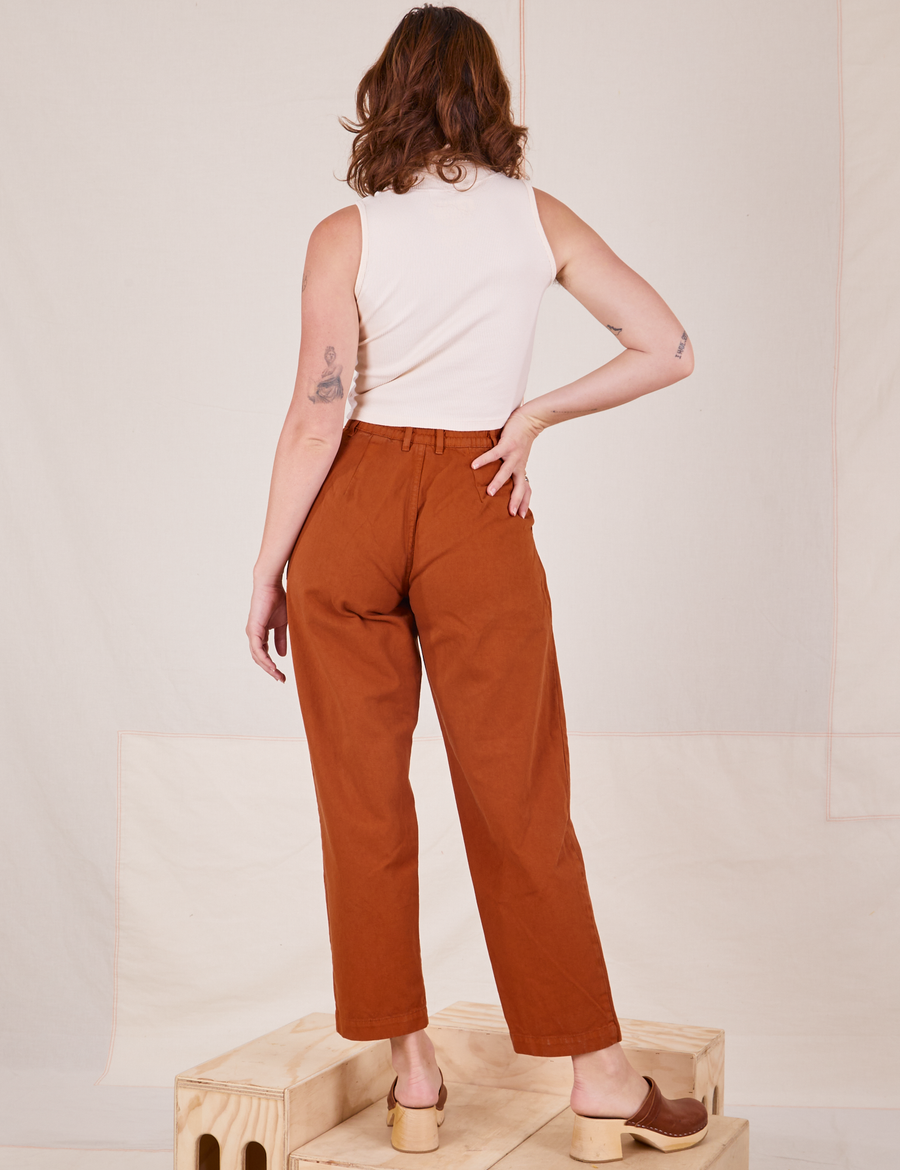 Back view of Heavyweight Trousers in Burnt Terracotta and vintage off-white Sleeveless Turtleneck worn by Alex
