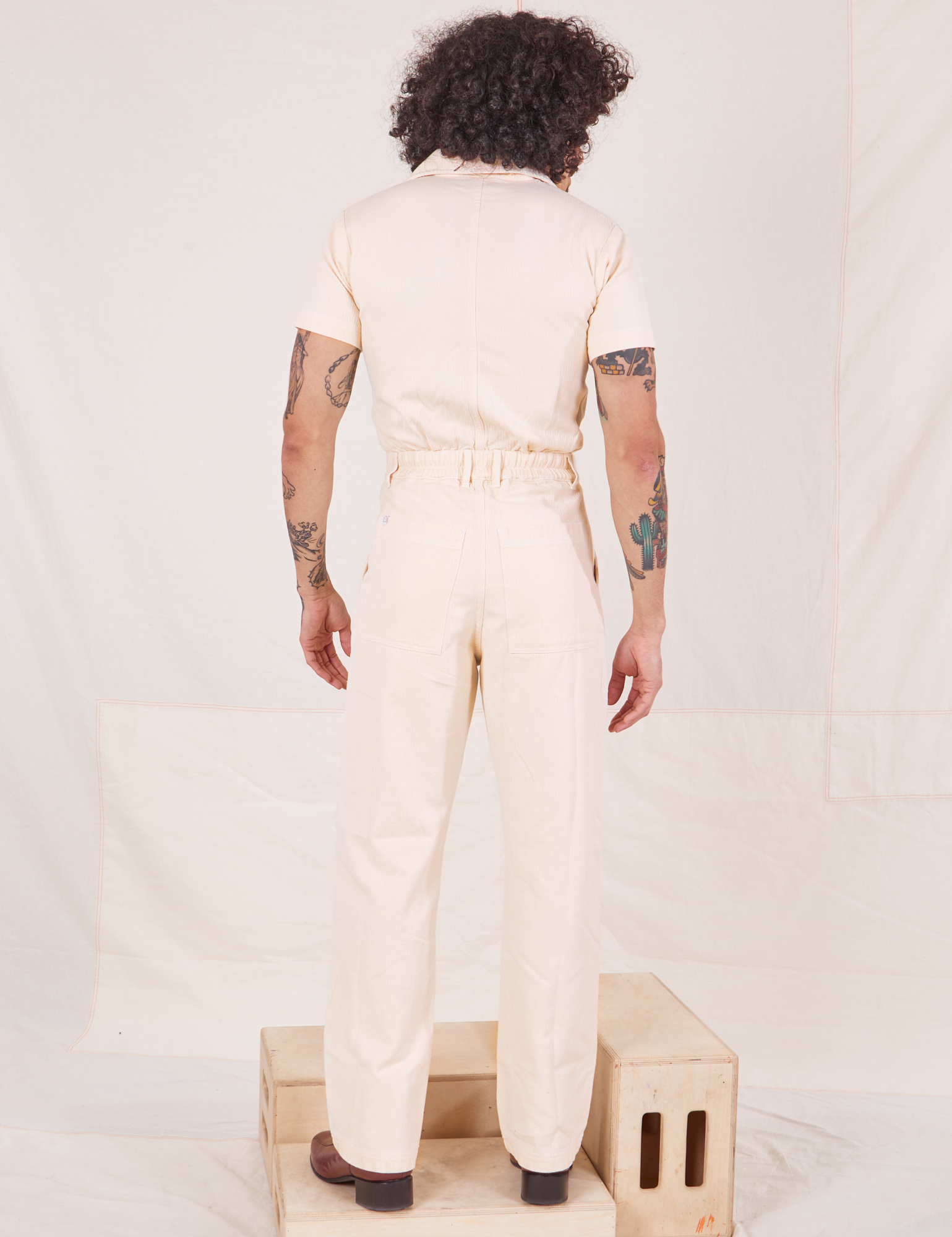 Back view of Heritage Short Sleeve Jumpsuit in Natural worn by Jesse