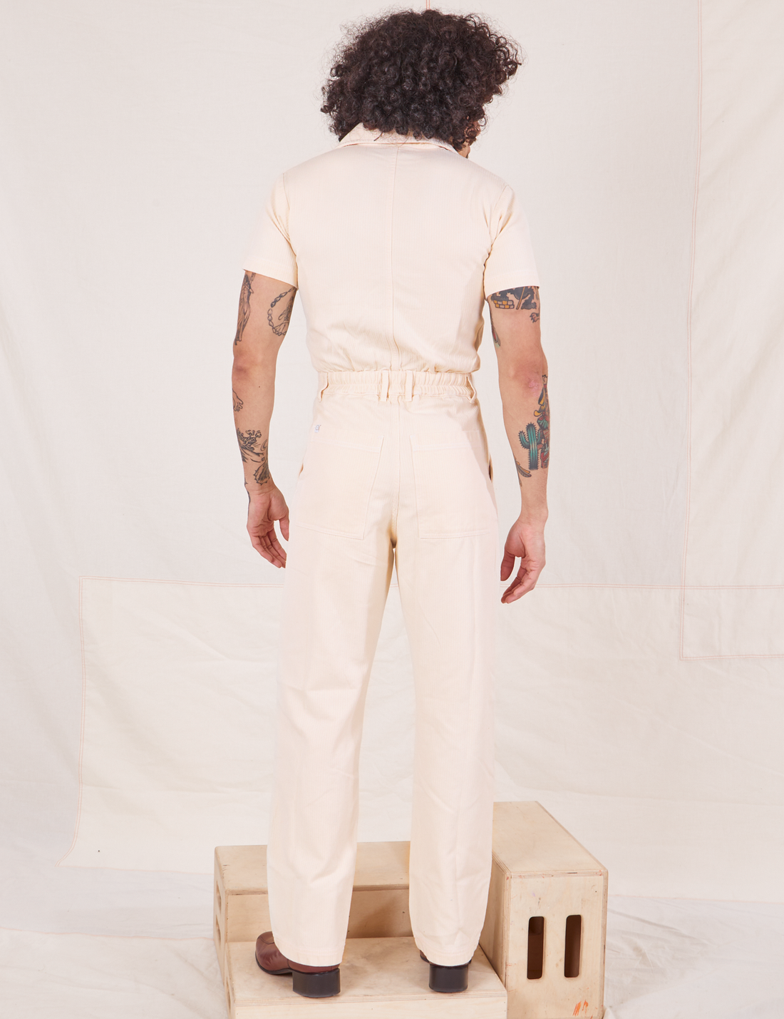 Back view of Heritage Short Sleeve Jumpsuit in Natural worn by Jesse