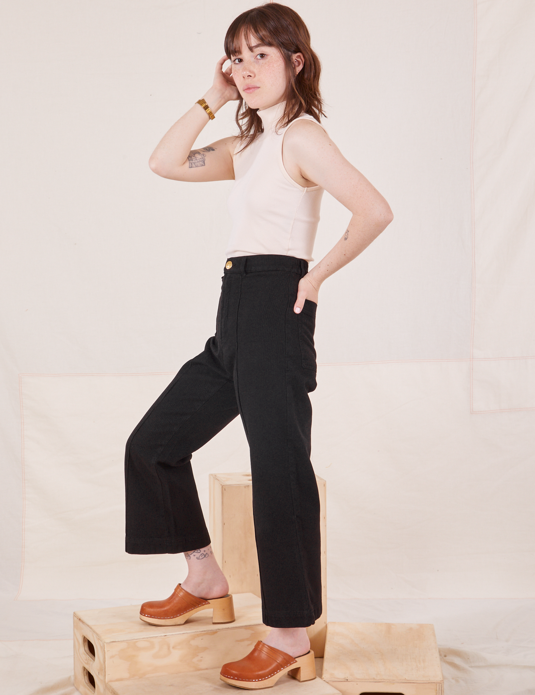 Side view of Heritage Westerns in Basic Black and vintage off-white Turtleneck worn by Hana