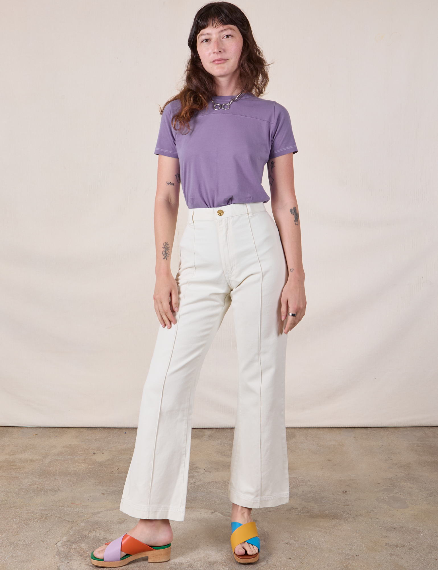 Alex is wearing Jr. Varsity Tee in Faded Grape tucked into vintage tee off-white Western Pants