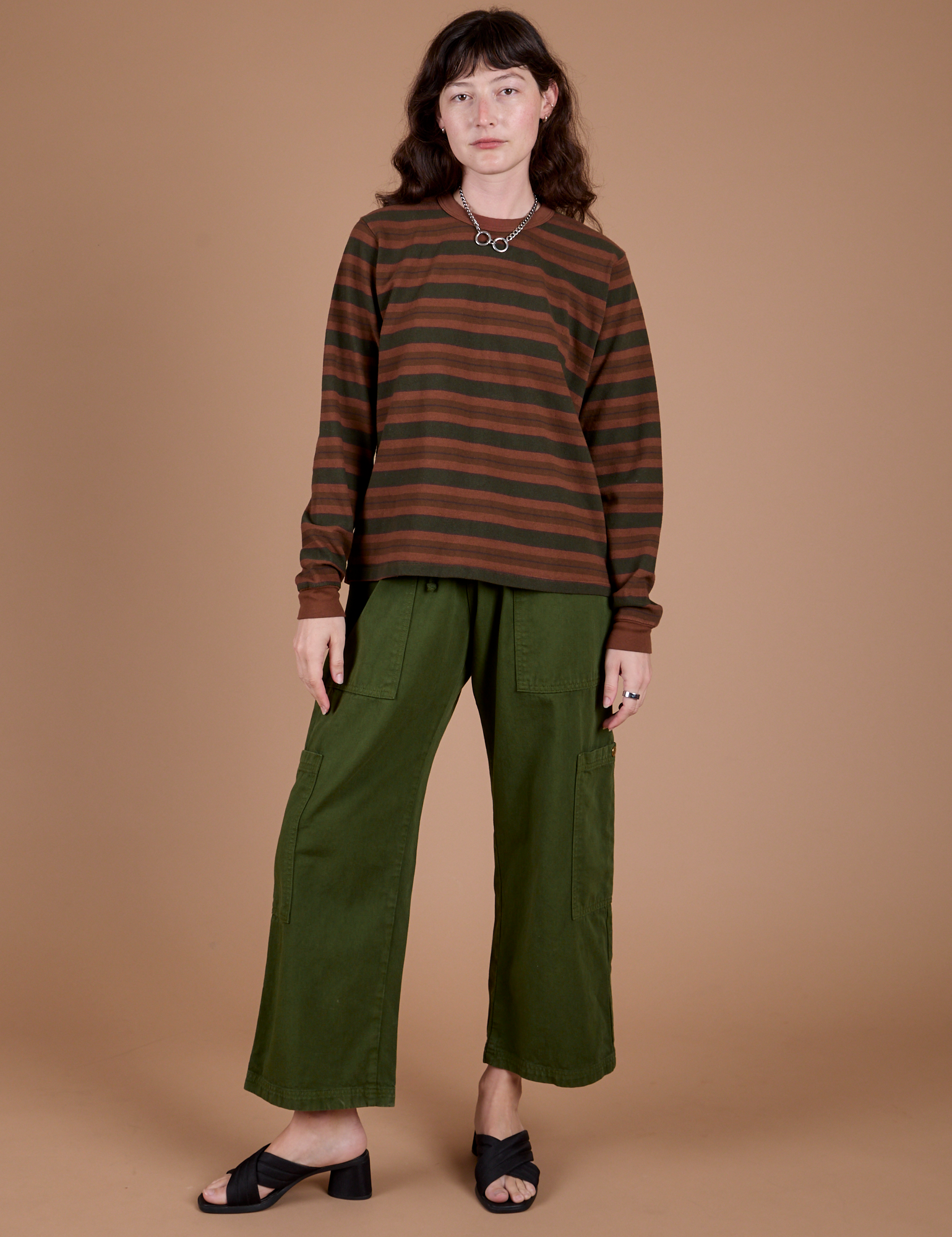 Alex is wearing Long Sleeve Striped Burly Tee in Fudgesicle and Drop Pocket Cargo Pants in Evergreen