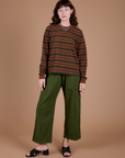 Alex is wearing Long Sleeve Striped Burly Tee in Fudgesicle and Drop Pocket Cargo Pants in Evergreen