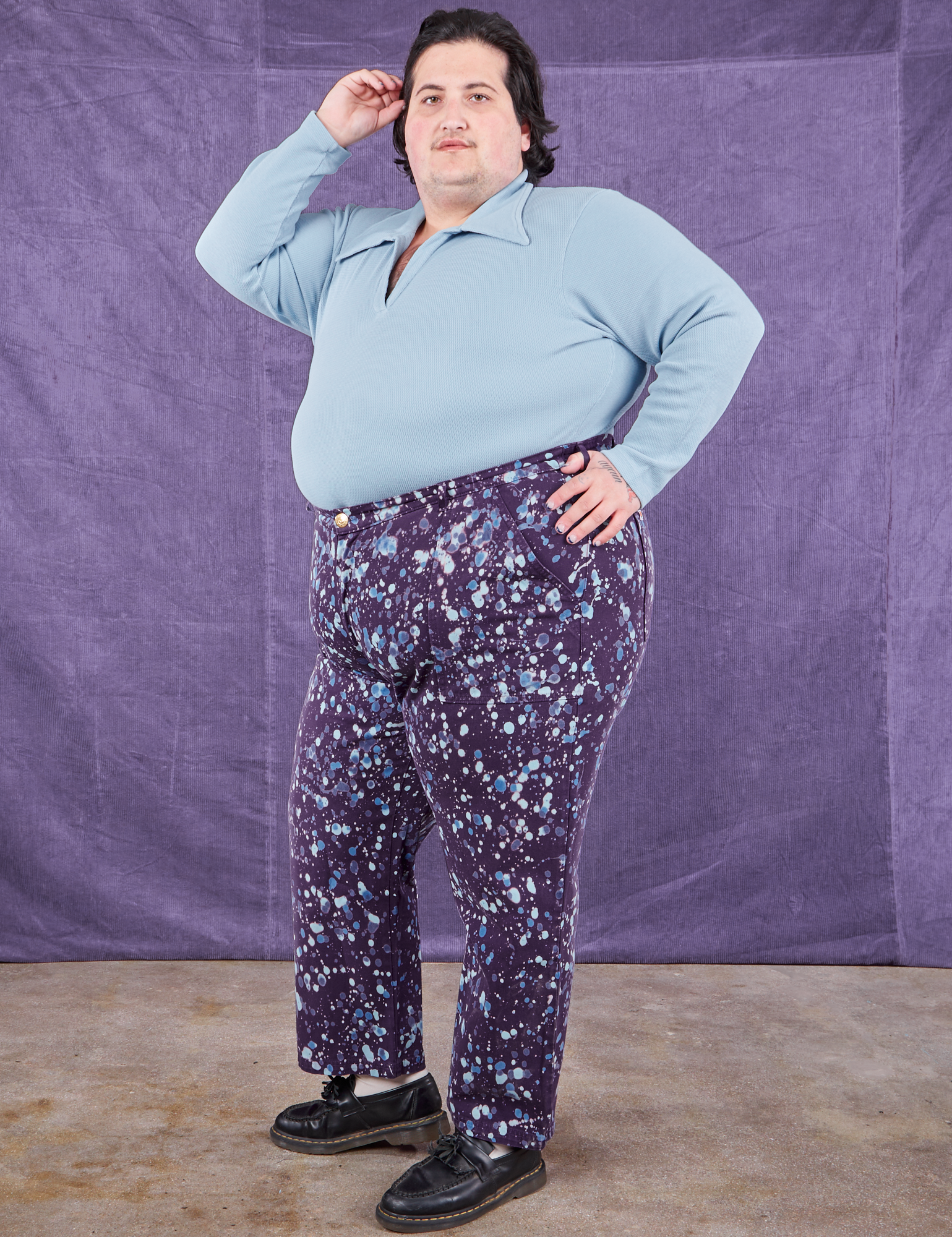 Angled front view of Marble Splatter Work Pants in Nebula Purple and baby blue Long Sleeve Fisherman Polo on Sam