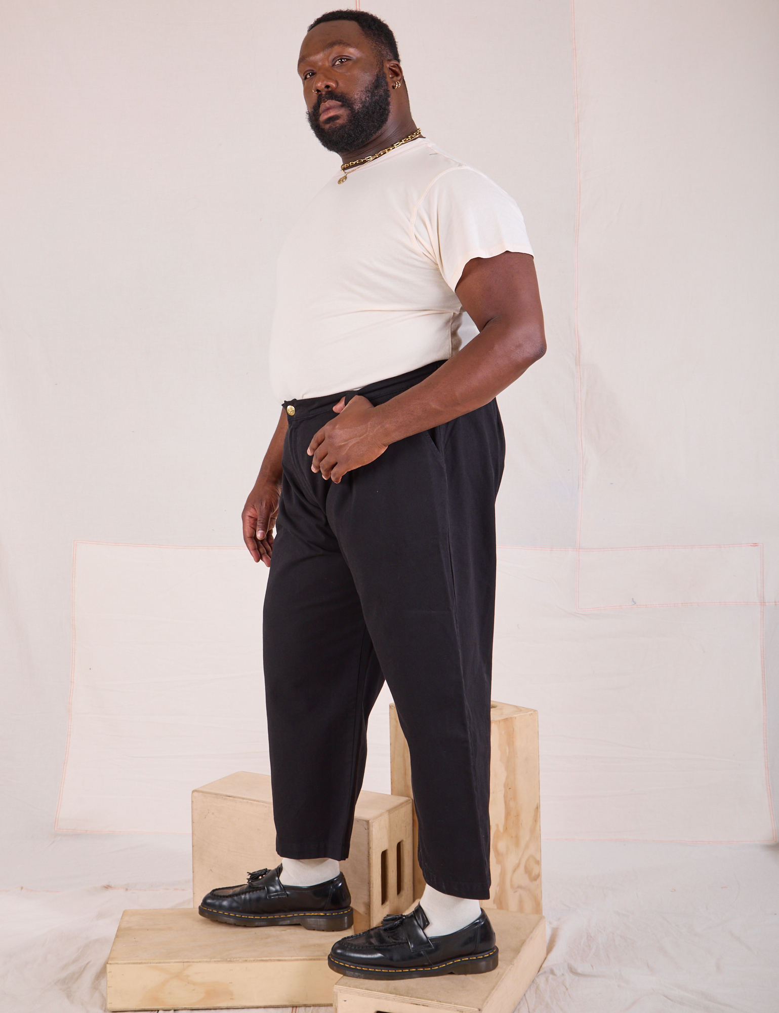 Side view of Mid-Rise Pleated Trousers in Basic Black and Organic Vintage Tee in vintage tee off-white on Elijah