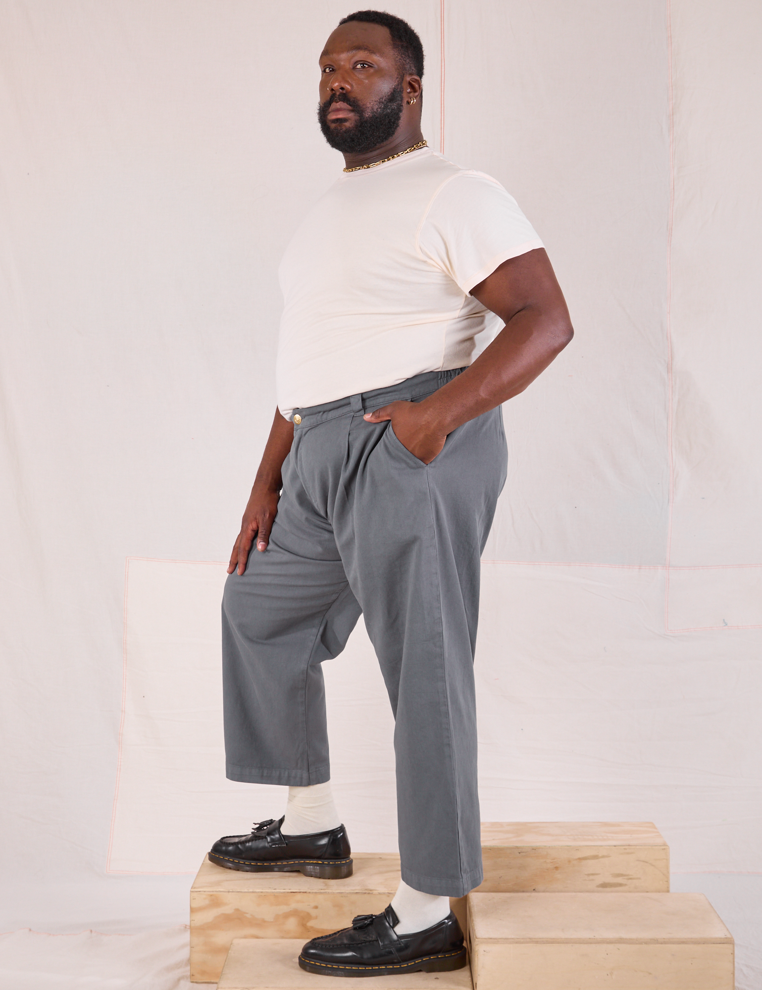 Side view of Mid-Rise Pleated Trousers in Slate Grey and Organic Vintage Tee in vintage tee off-white on Elijah