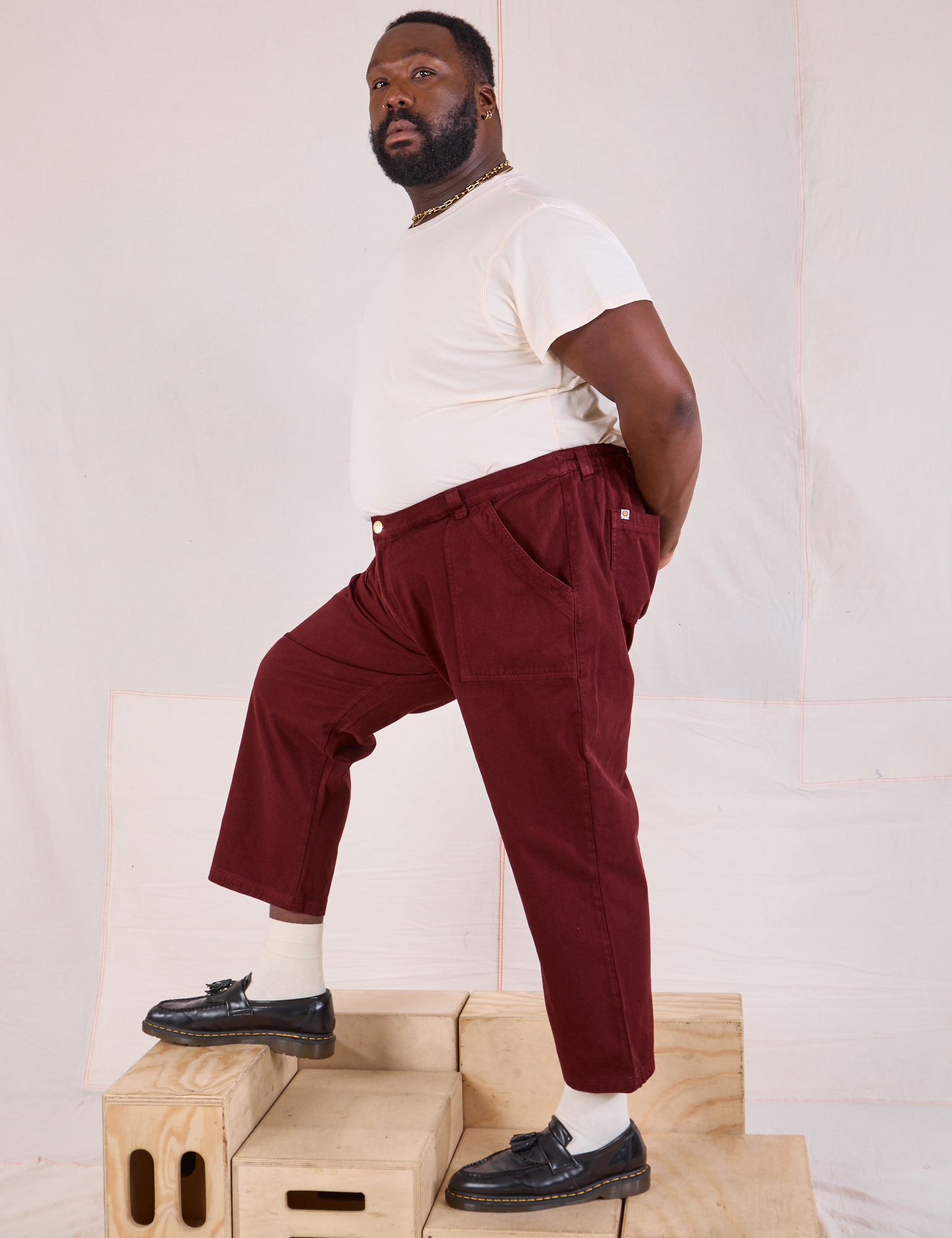 Side view of Mid-Rise Work Pants in Red Wine and Organic Vintage Tee in vintage tee off-white on Elijah