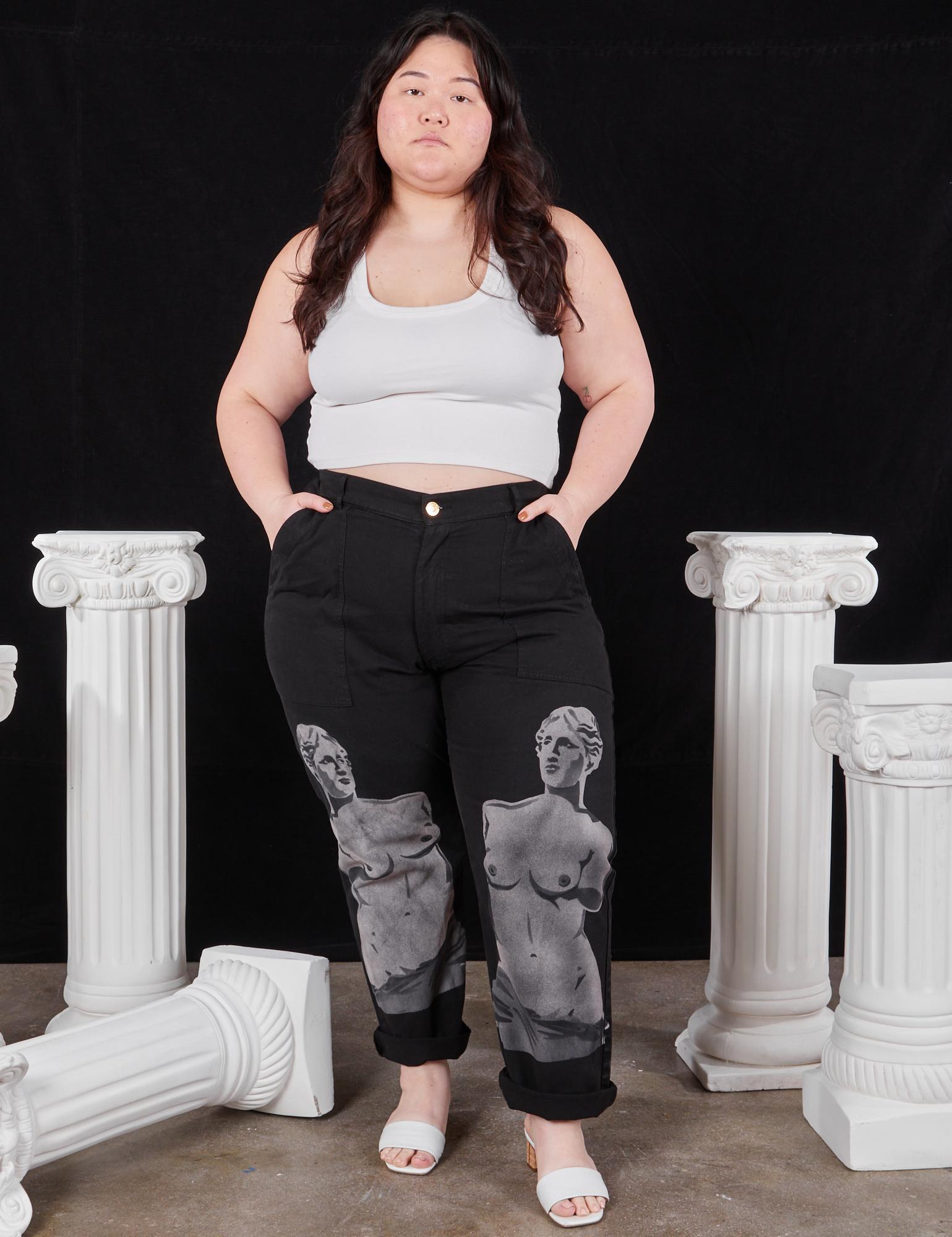 Ashley is 5&#39;7&quot; and wearing 1XL Black Venus Work Pants paired with vintage off-white Cropped Tank Top