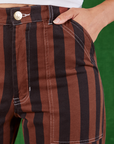 Black Stripe Work Pants in Fudgesicle Brown front close up. Tiara has her hand in the pocket.