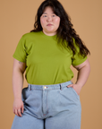 Ashley is wearing Organic Vintage Tee in Gross Green tucked into light wash Indigo Wide Leg Trousers