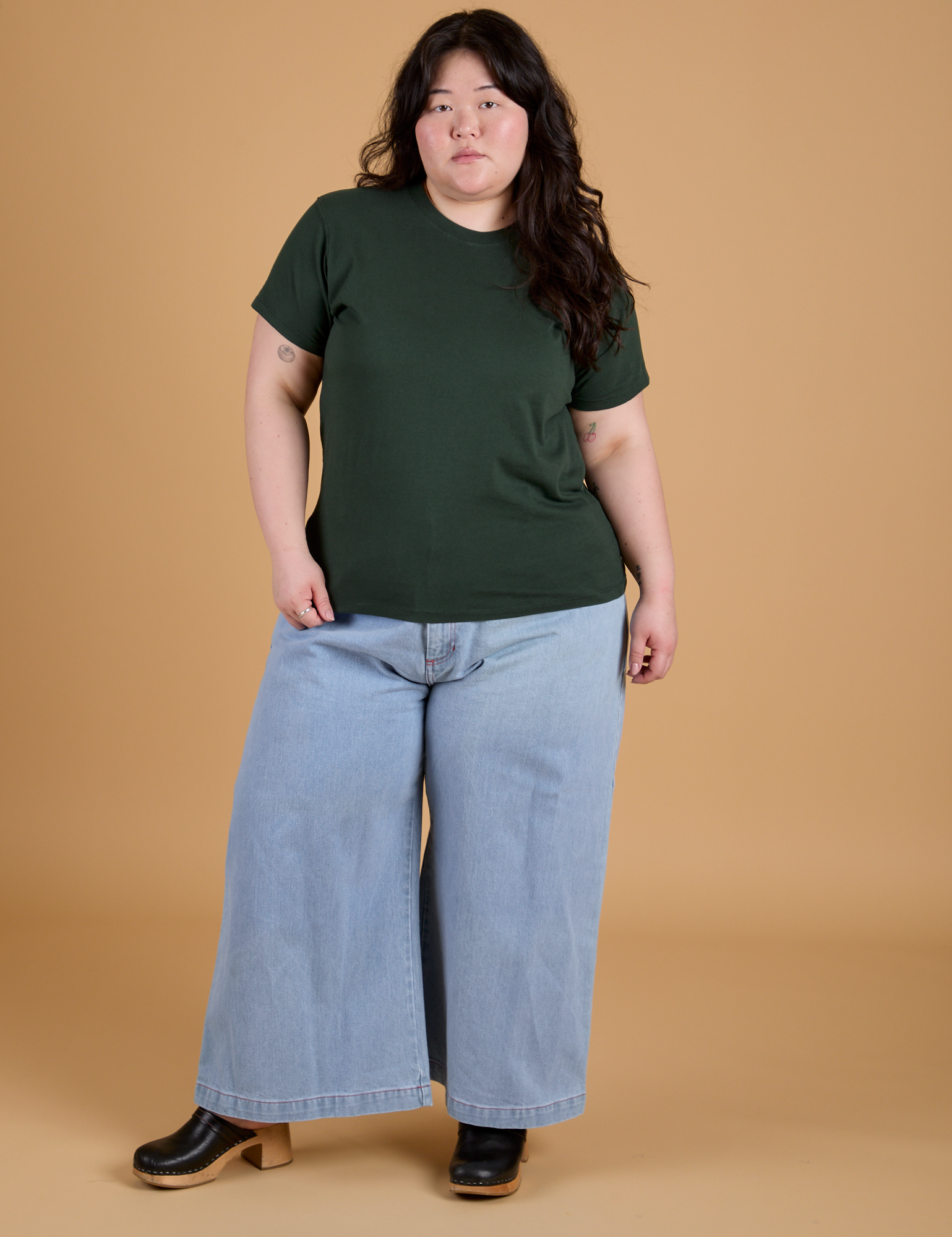 Ashley is wearing Organic Vintage Tee in Swamp Green and light wash Indigo Wide Leg Trousers