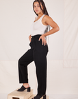 Side view of Organic Trousers in Basic Black and vintage off-white Tank Top worn by Gabi