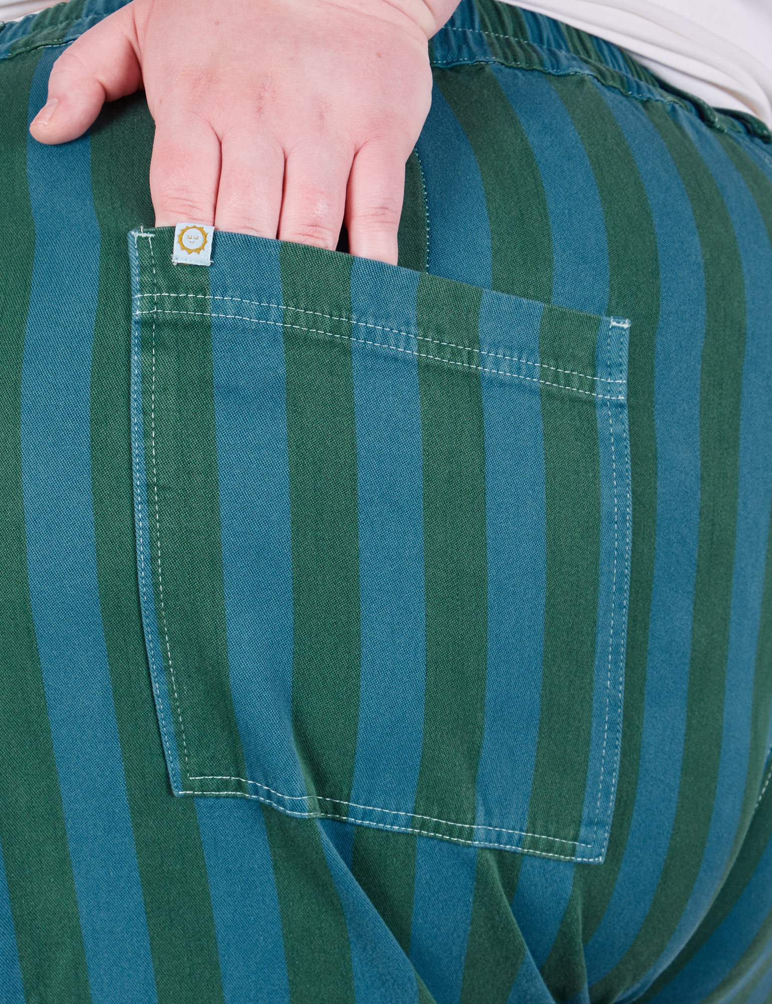Overdye Stripe Work Pants in Blue/Green back pocket close up. Catie had her hand tucked into the pocket.