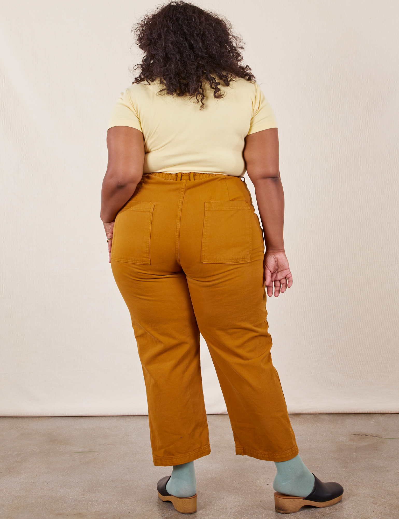 Work Pants in Spicy Mustard back view on Morgan wearing butter yellow Baby Tee