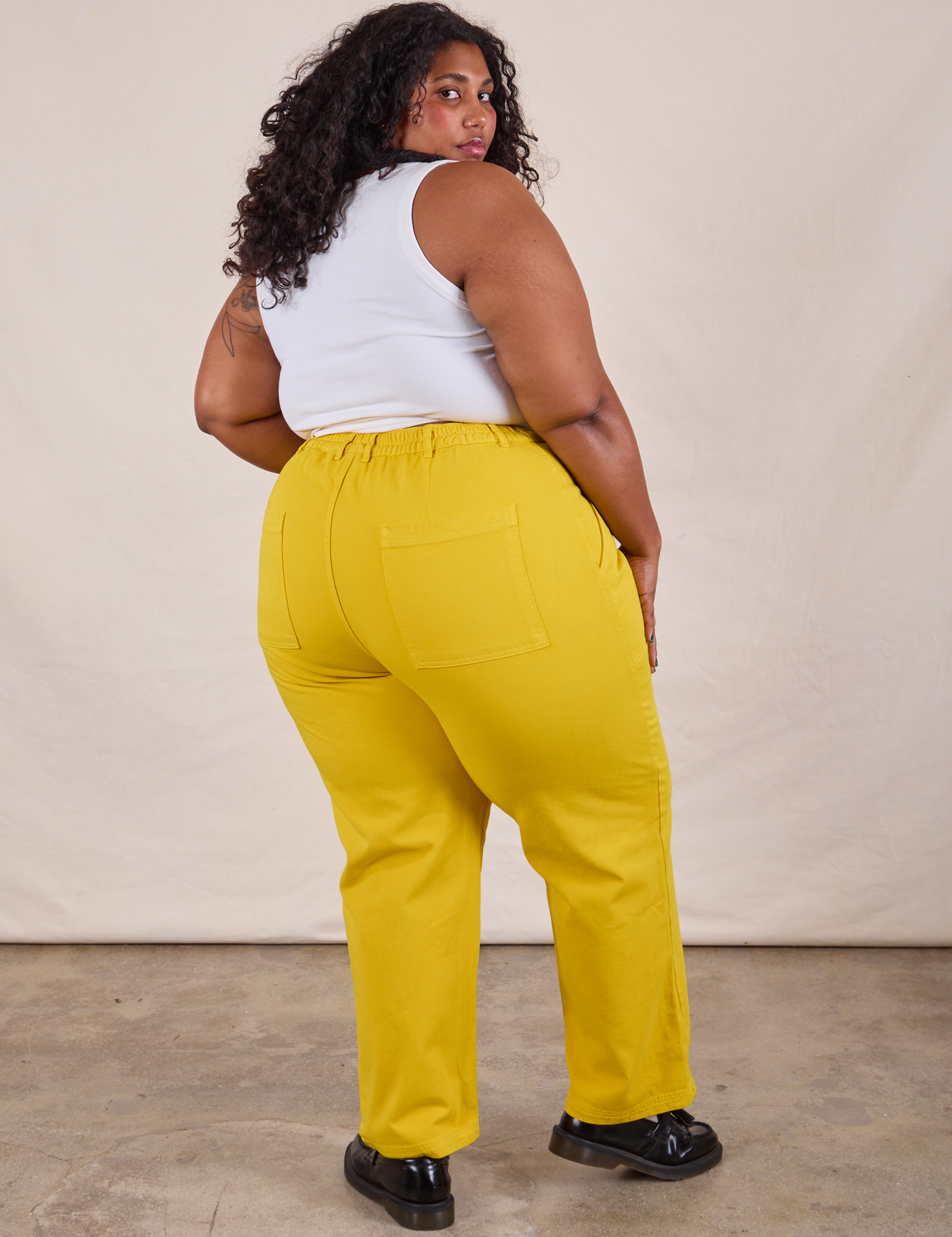 Back view of Work Pants in Golden Yellow and Cropped Tank in Vintage Tee Off-White on Morgan