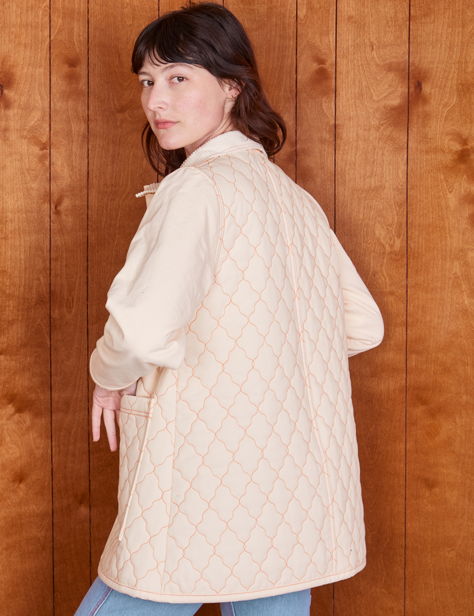 Angled back view of Quilted Overcoat in Vintage Off-White on Alex