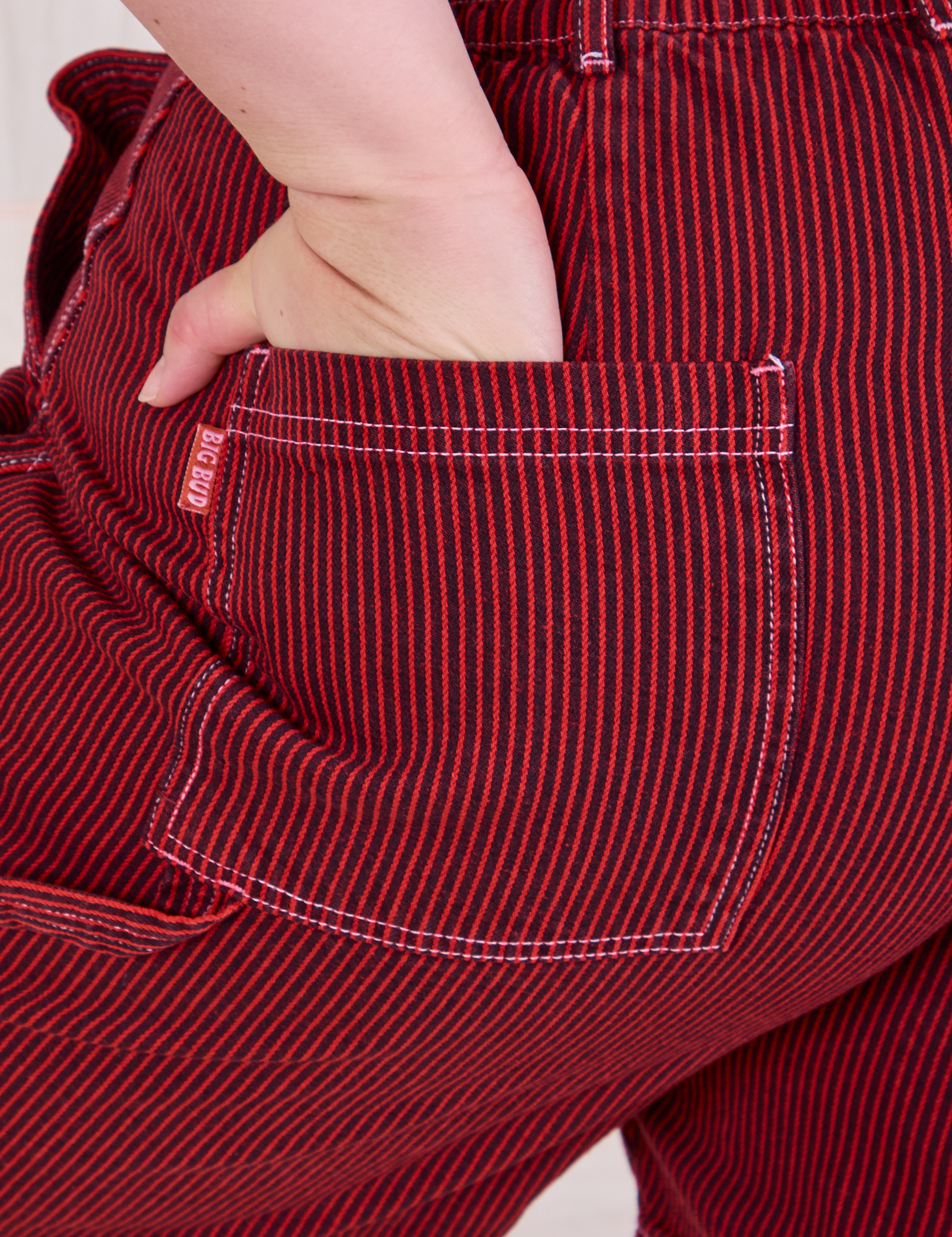 Close up of Ashley&#39;s hand in the back pocket of Railroad Carpenter Shorts in Mustang Red