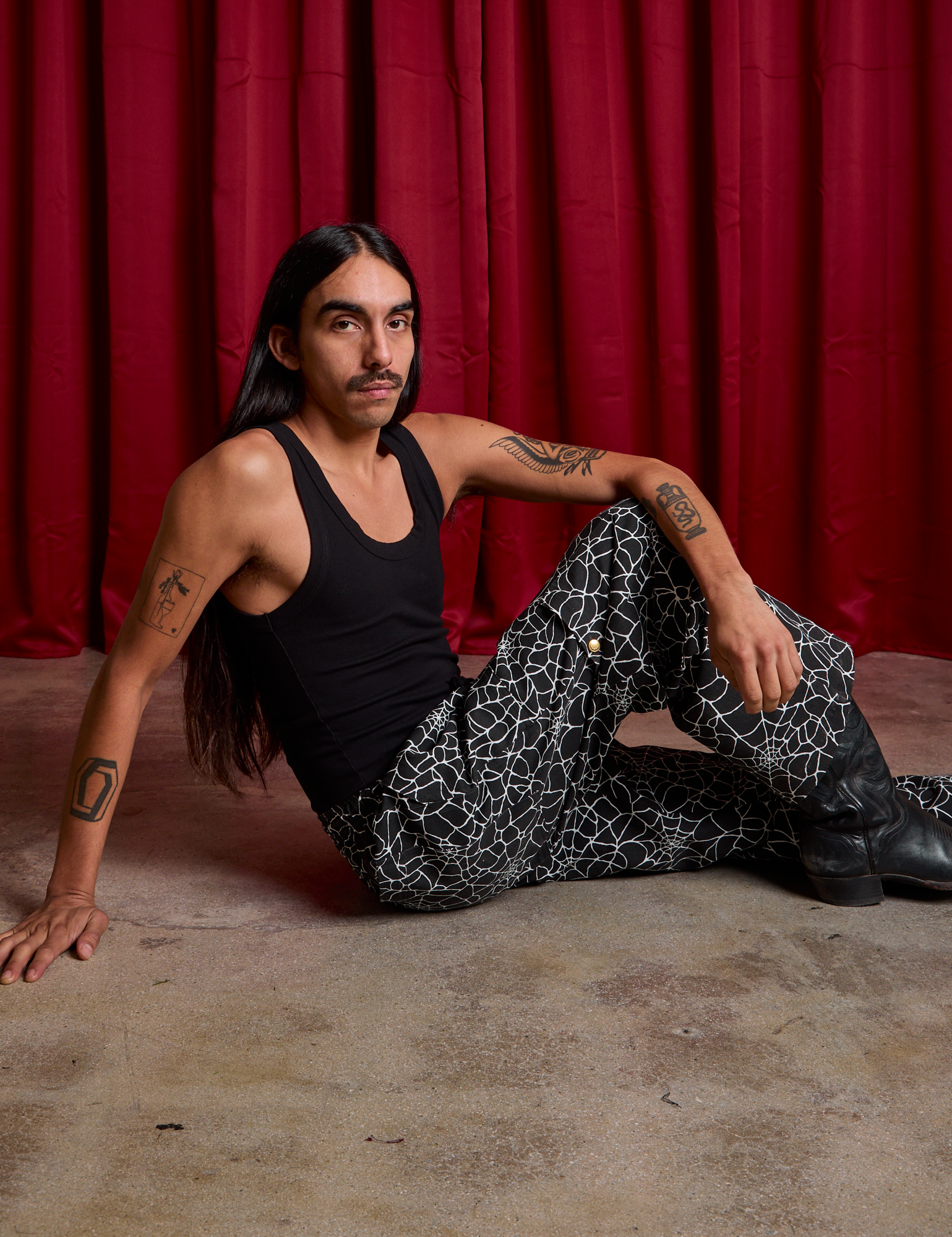 Anthony is wearing Drop Pocket Cargo Pants in Spider Webs and black Cropped Tank