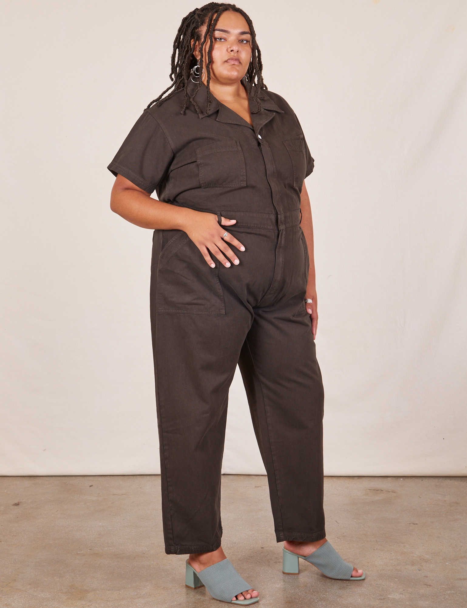 Angled view of Short Sleeve Jumpsuit in Espresso Brown worn by Alicia