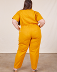 Back view of Short Sleeve Jumpsuit in Mustard Yellow worn by Marielena