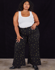 Morgan is 5'5" and wearing 1XL Star Bell Bottoms in Black paired with a Cropped Tank in vintage tee off-white