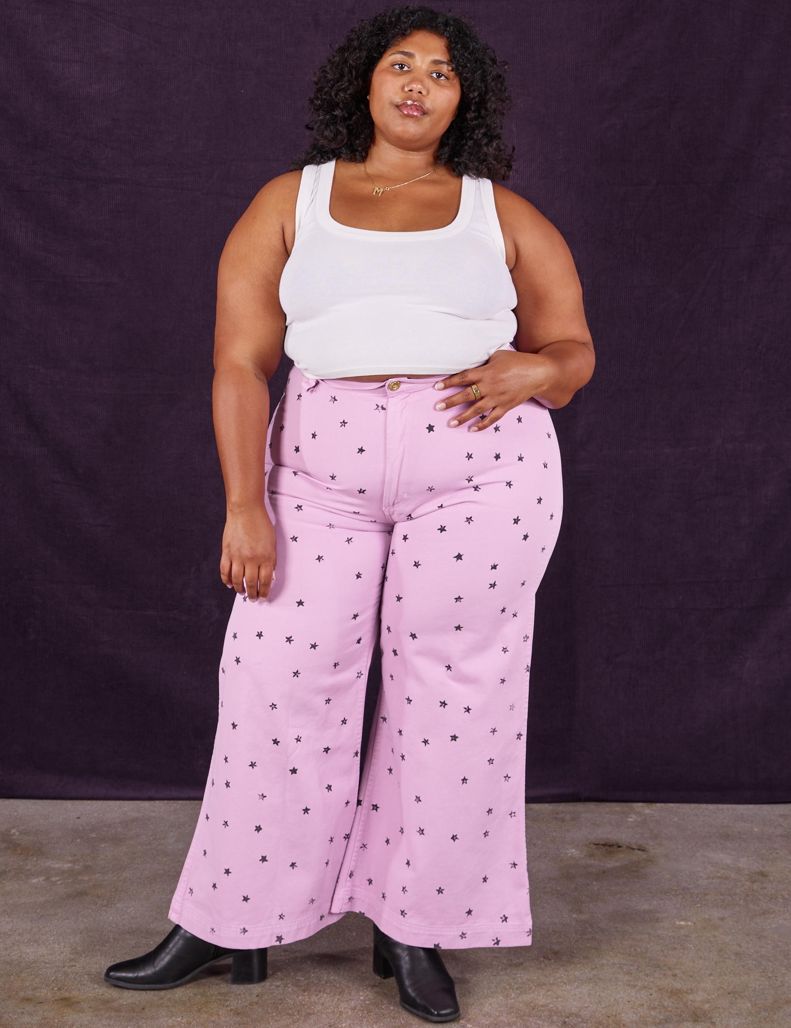 Morgan is 5&#39;5&quot; and wearing 1XL Star Bell Bottoms in Lilac Purple paired with a Cropped Tank in vintage tee off-white