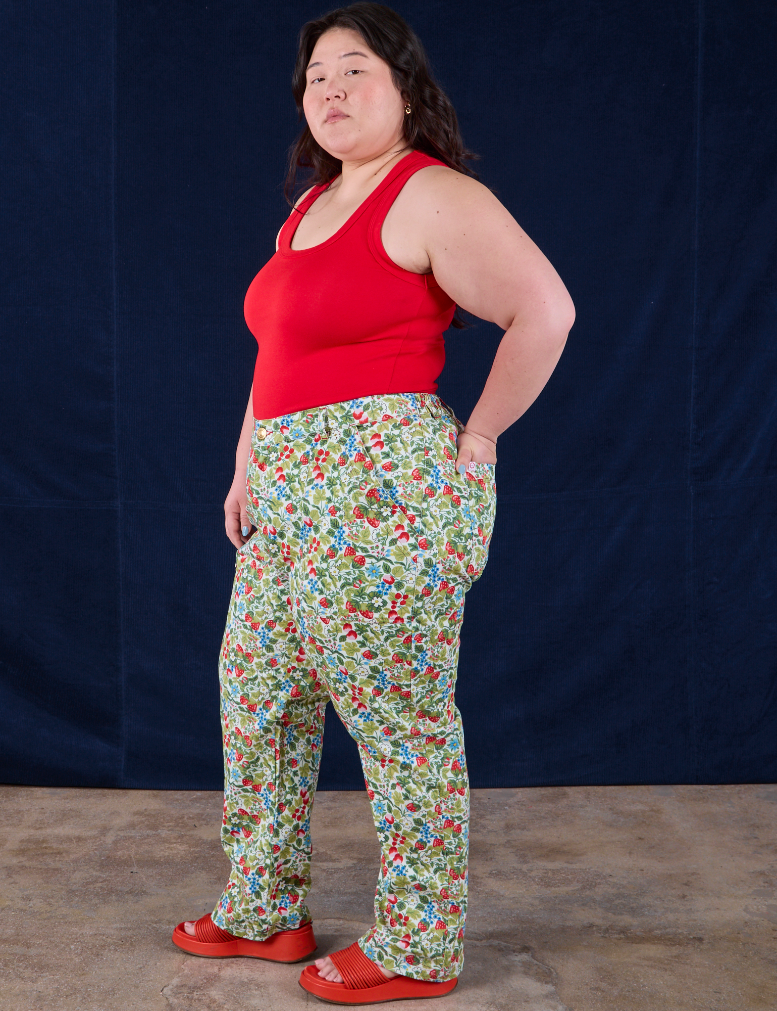 Side view of Work Pants in Strawberry Blossom and mustang red Tank Top on Ashley