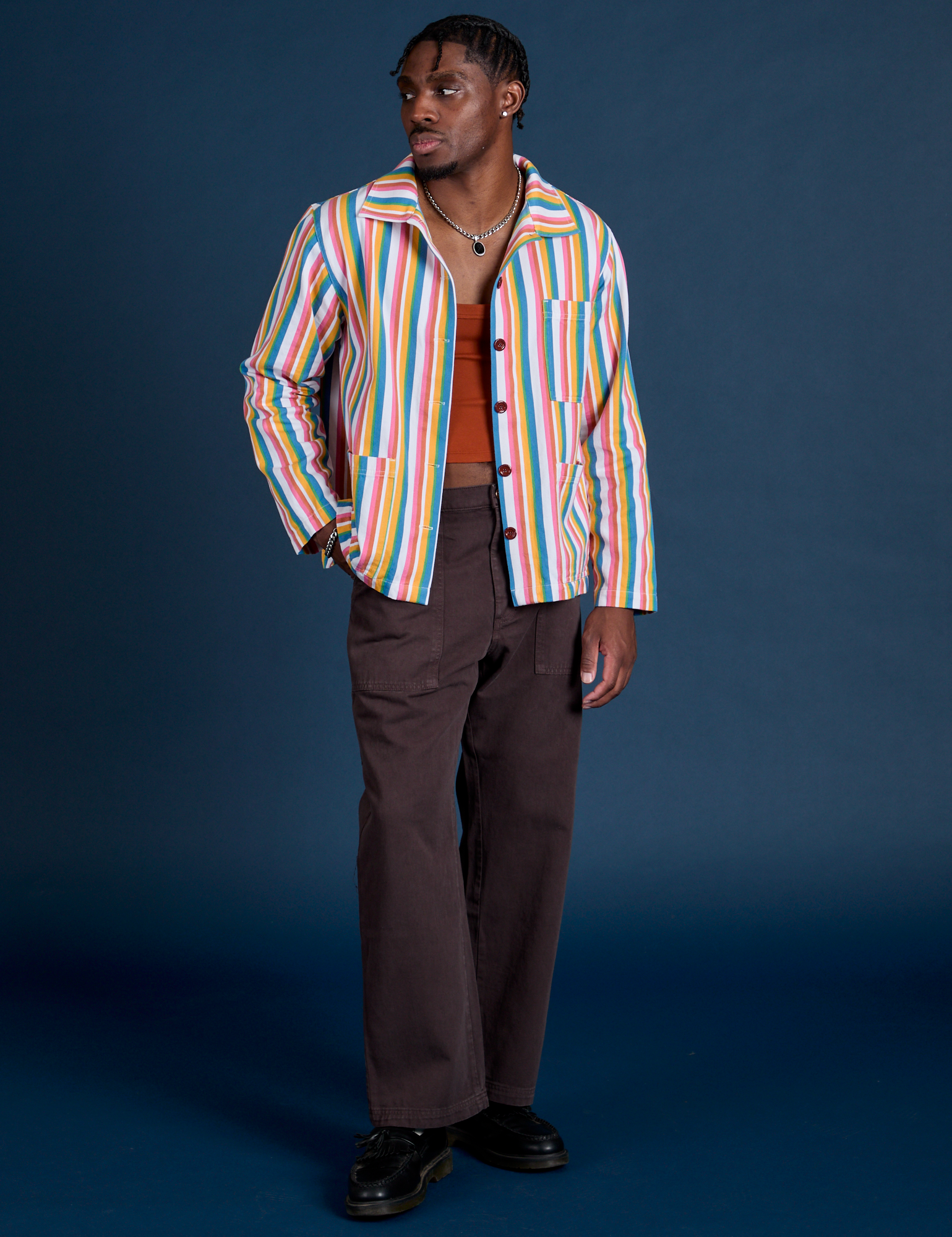 Isaac is wearing  Stripe Work Jacket in Rainbow Stripe paired with espresso Work Pants 