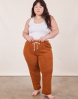 Ashley is 5'7" and wearing XL Cropped Rolled Cuff Sweatpants in Burnt Terracotta paired with vintage off-white Cropped Tank Top