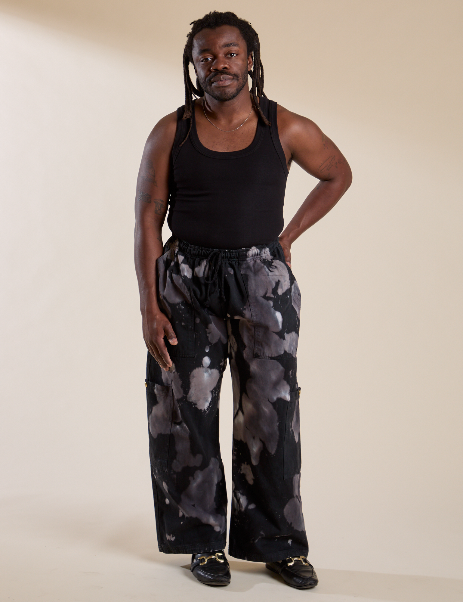 Demi is 5'6" and wearing S Magic Waters Drop Pocket Pants in Ink Blot paired with black Cropped Tank