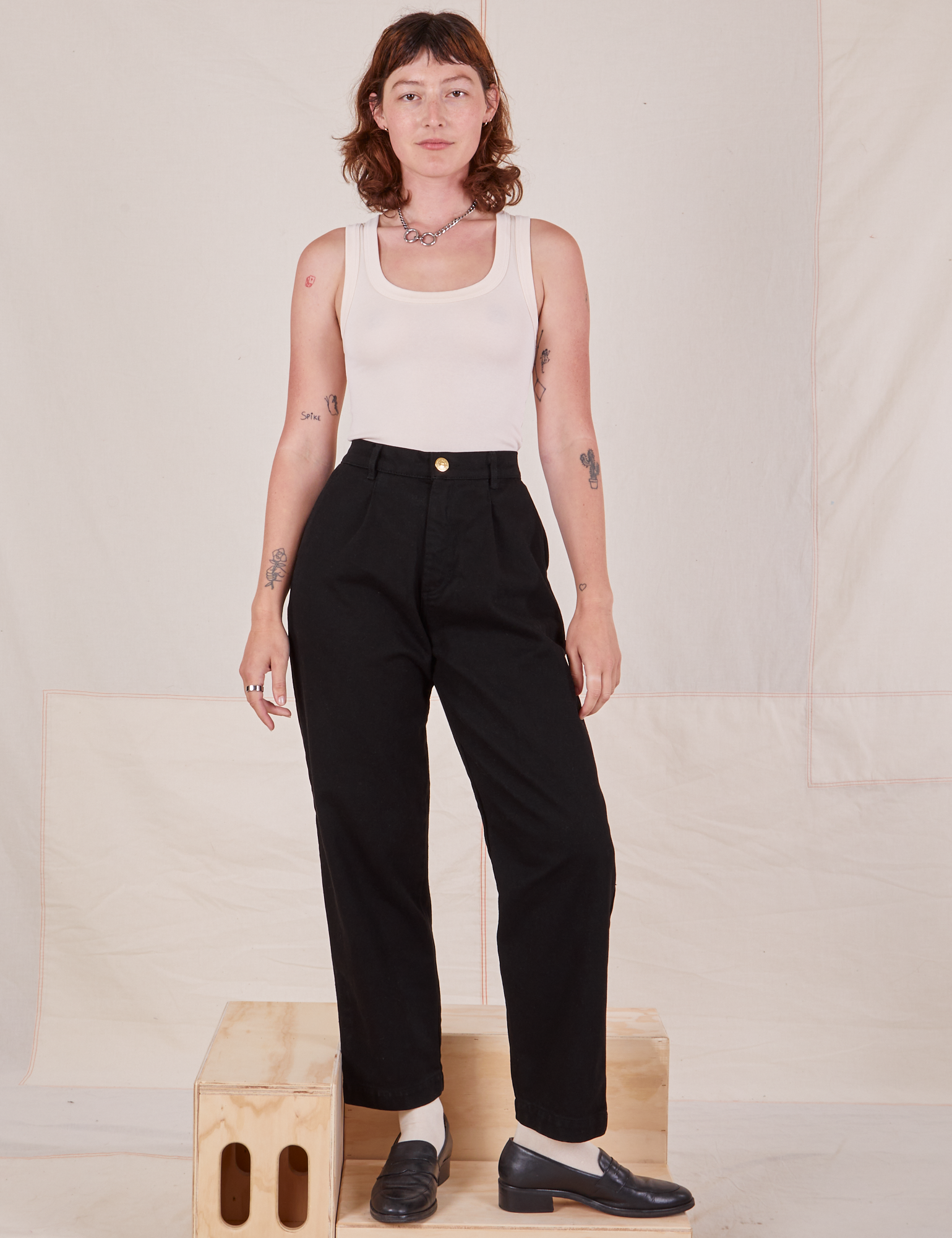 Alex is 5&#39;8&quot; and wearing XXS Denim Trouser Jeans in Black paired with a vintage off-white Tank Top