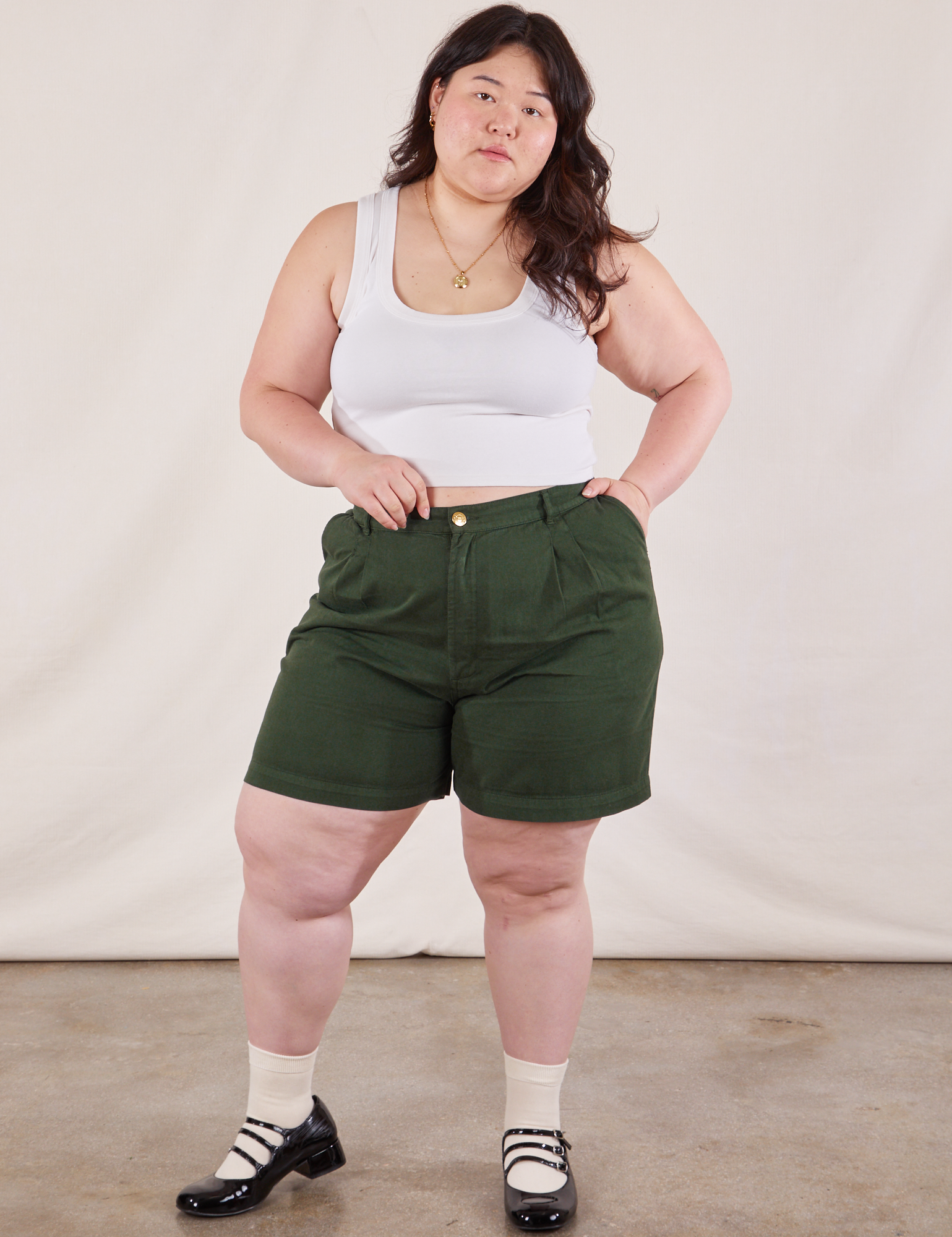 Ashley is 5&#39;7&quot; and wearing 0XL Trouser Shorts in Swamp Green paired with Cropped Tank in Vintage Tee Off-White