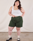 Ashley is 5'7" and wearing 0XL Trouser Shorts in Swamp Green paired with Cropped Tank in Vintage Tee Off-White