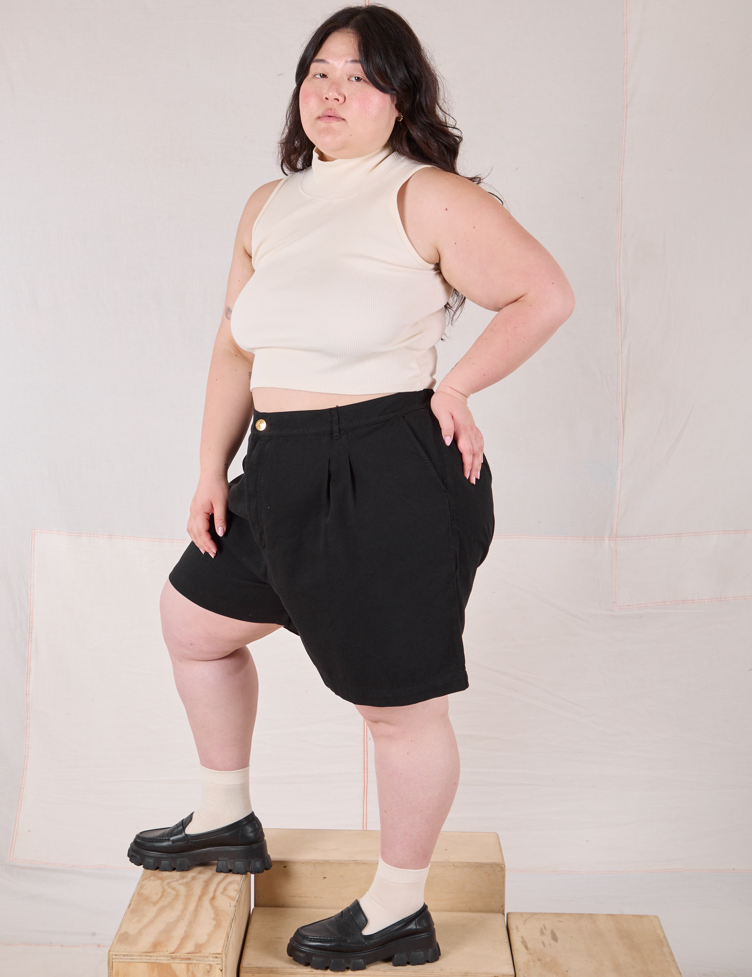 Side view of Trouser Shorts in Basic Black and Sleeveless Turtleneck in vintage tee off-white on Ashley
