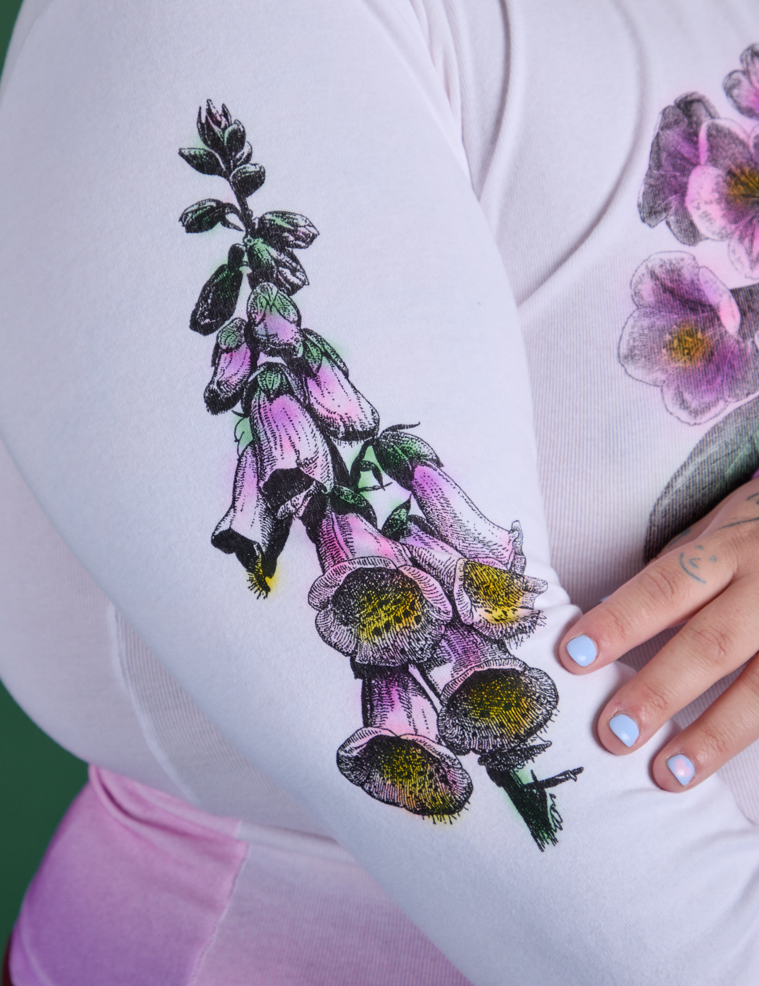 Close up of screen-print flower on sleeves of Floral Long Sleeve Baby Tee in Pink