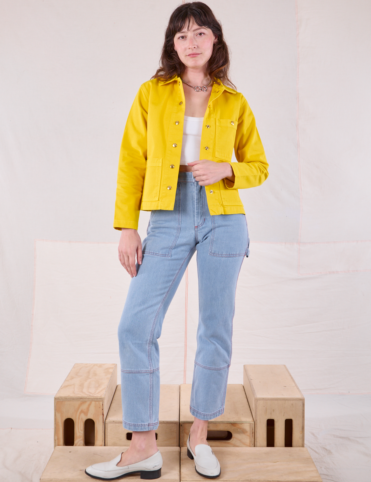 Alex is wearing Denim Work Jacket in Golden Yellow and light wash Carpenter Jeans