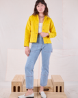 Alex is wearing Denim Work Jacket in Golden Yellow and light wash Carpenter Jeans