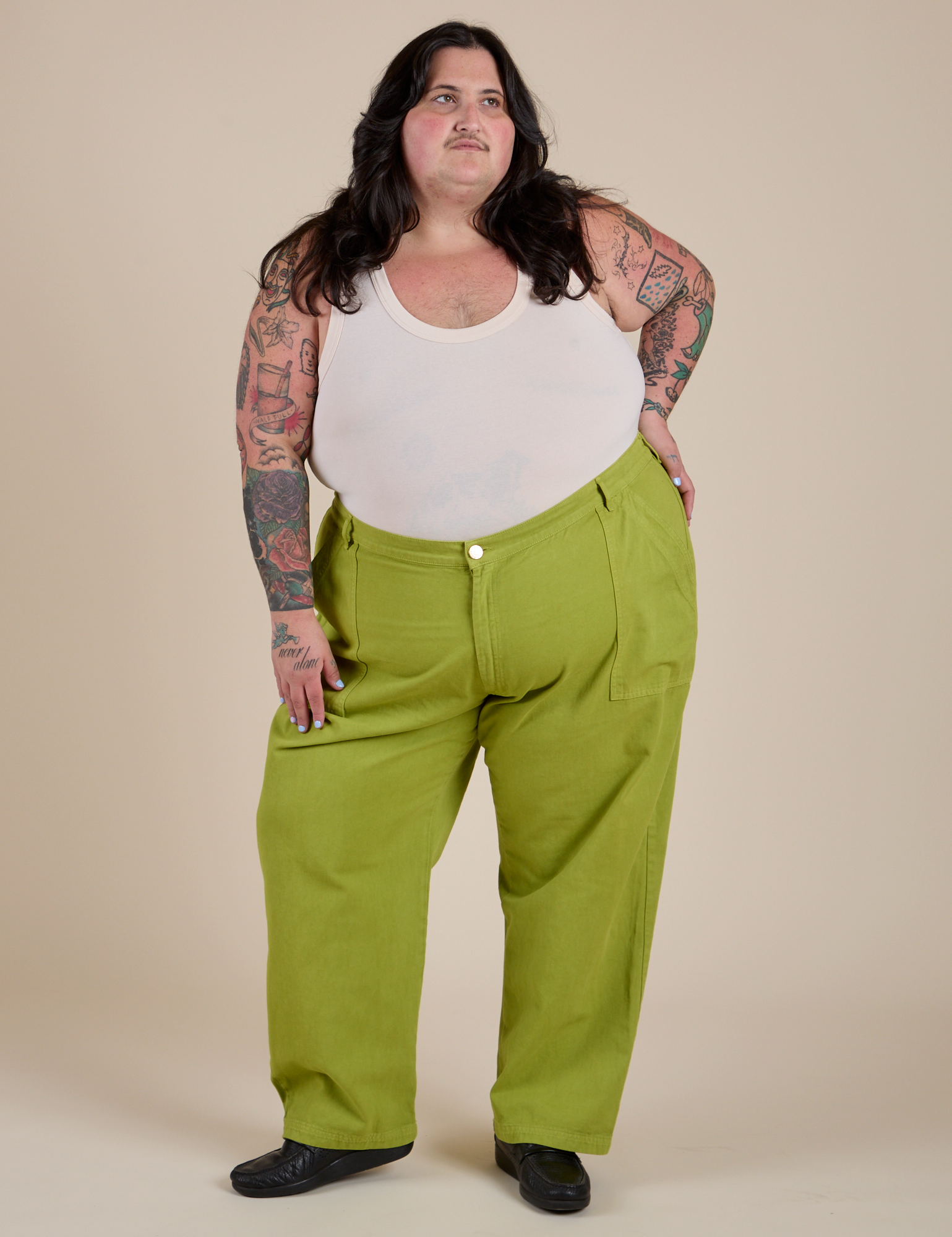 Sam is wearing Work Pants in Gross Green and Cropped Tank in Vintage Tee White