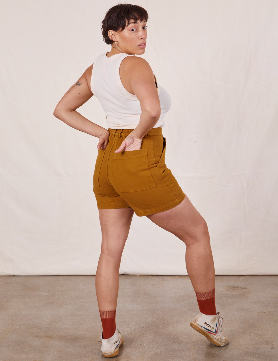 Angled view of Classic Work Shorts in Spicy Mustard and vintage off-white Tank Top worn by Tiara