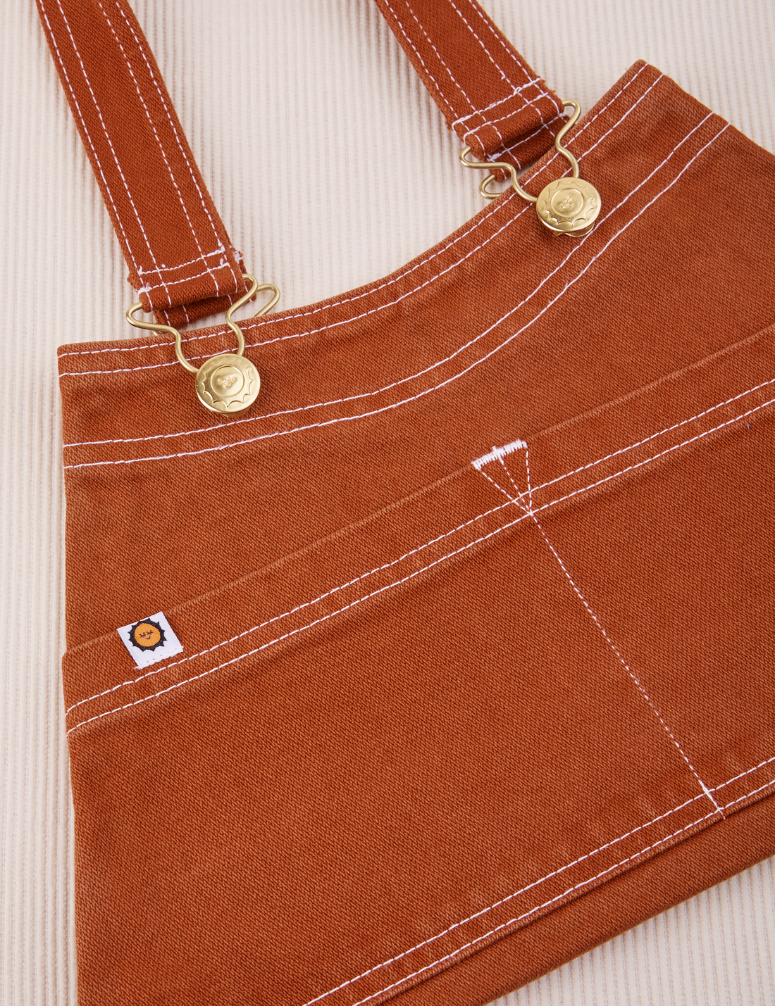 Overall Handbag in Burnt Terracotta. Contrast white stitching. Brass sun baby buttons and hardware