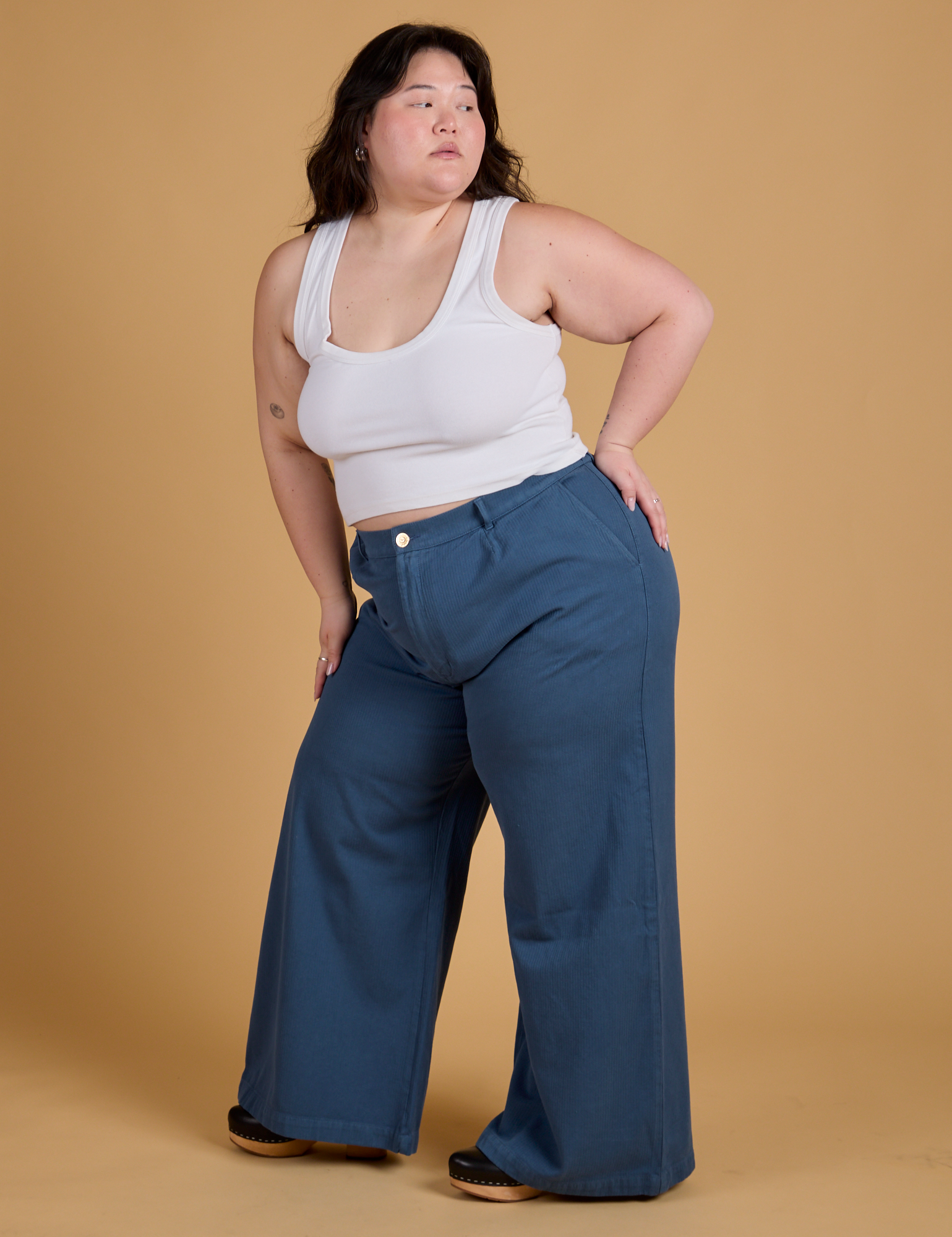 Angled front view of Heritage Wide Leg Trousers in French Blue and vintage tee white Cropped Tank on Ashley