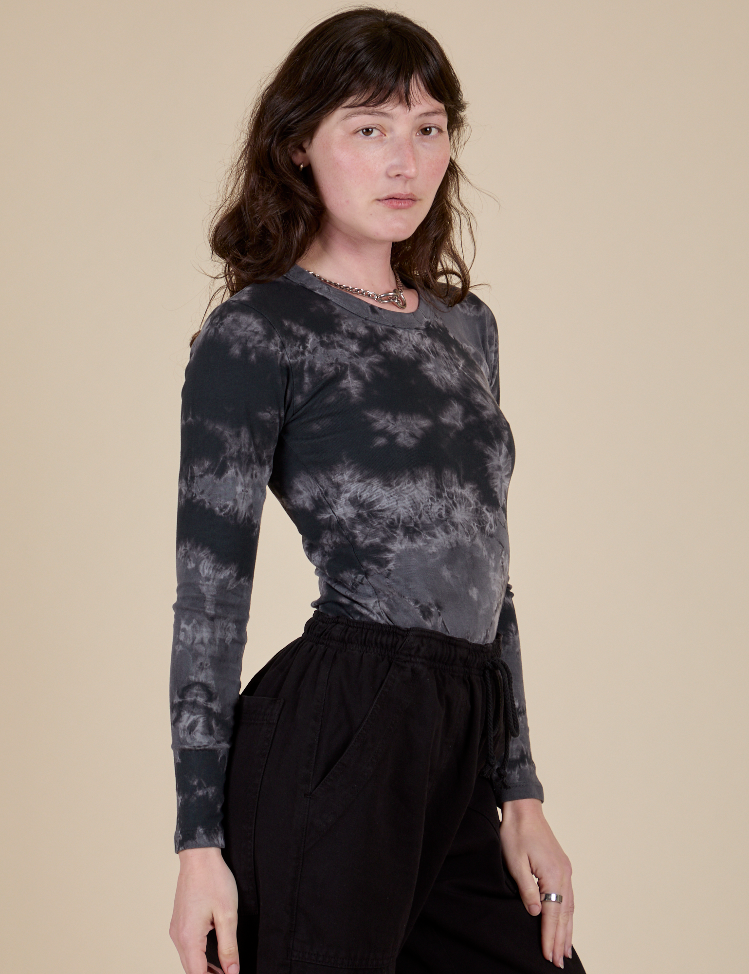 Angled front view of Long Sleeve Baby Tee in Black Magic Waters on Alex