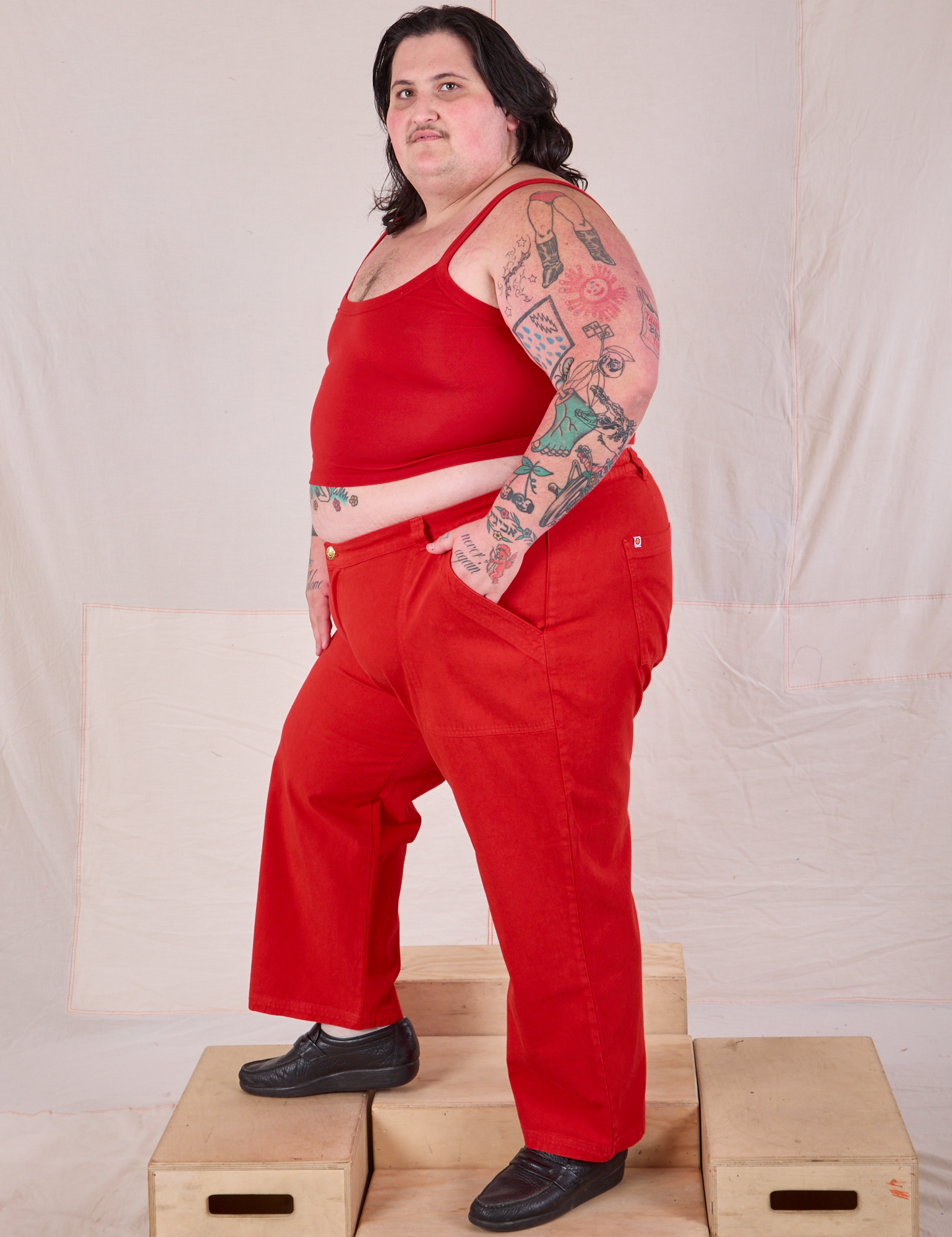 Side view of Mid-Rise Work Pants in Mustang Red and matching Cropped Cami on Sam