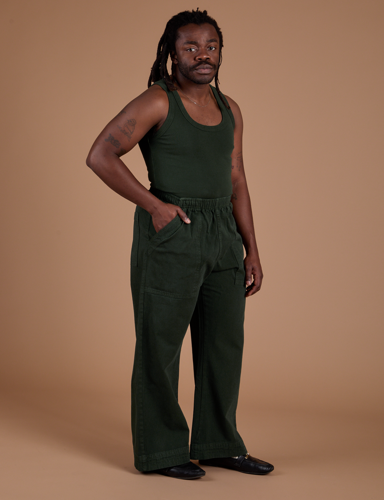 Angled front view of Action Pants in Swamp Green and swamp green Tank Top on Demi