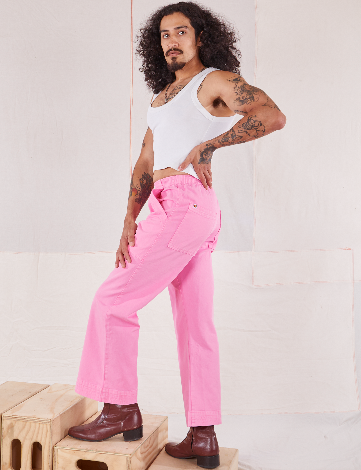 Side view of Action Pants in Bubblegum Pink and Cropped Tank in vintage tee off-white worn by Jesse