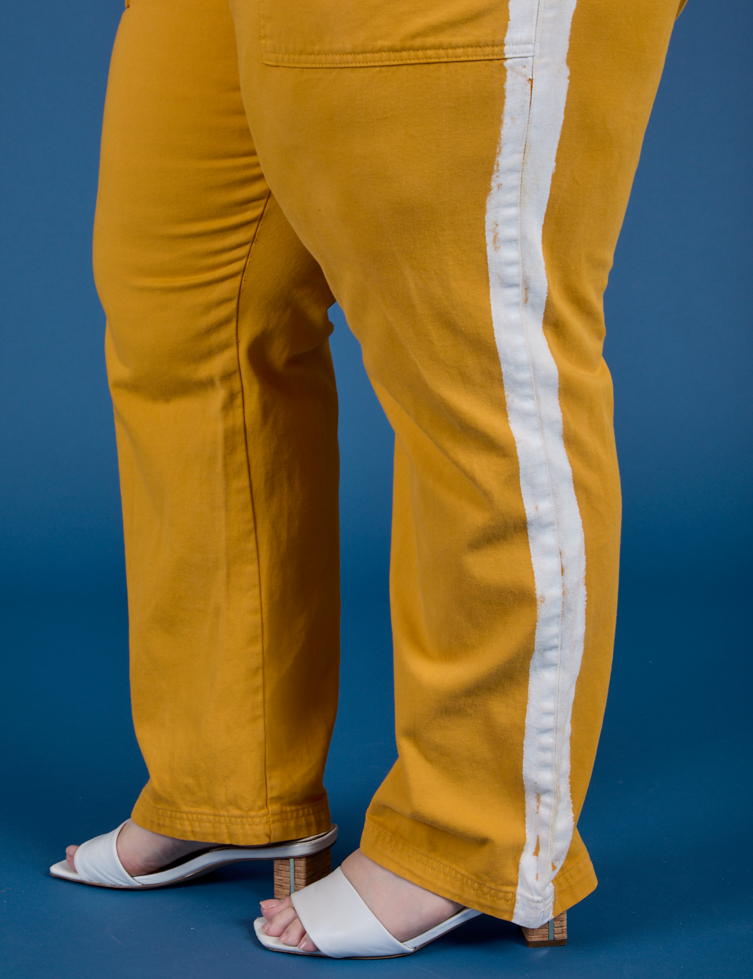 Painted Work Pants in Mustard Yellow pant leg side view close up on Ashley