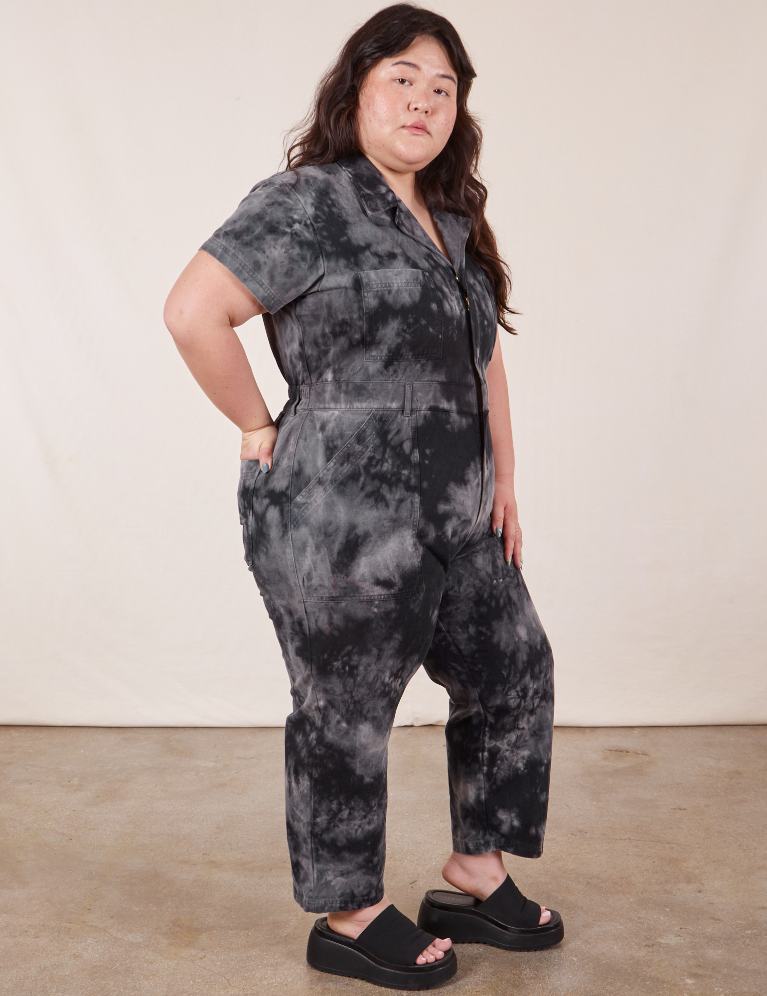 Side view of Petite Short Sleeve Jumpsuit in Black Magic Waters worn by Ashley