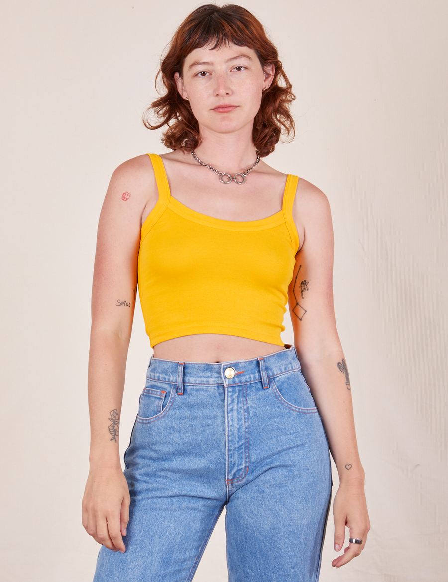 Alex is 5'8" and wearing P Cropped Cami in Sunshine Yellow paired with light wash Frontier Jeans
