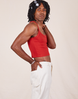 Side view of Cropped Cami in Mustang Red and vintage off-white Western Pants worn by Jerrod