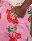 Close up of Isaac's hand in the front pocket of Cherry Paintstamped Work Pants in Bubblegum Pink